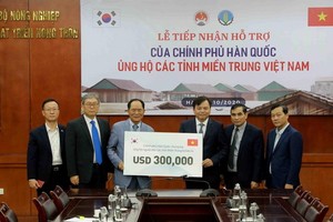 韓國駐越南特命全權大使樸能運（左三）將捐助款項移交予農業與農村發展部副部長、天災防範中央指委會副主任阮黃協。（圖源：越通社）