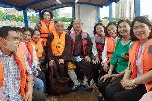 釋慧功法師與市越南祖國陣線委員會領導坐船考察豆腐涌。