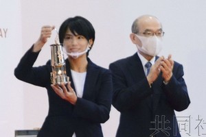 歡迎儀式上，該市出身的倫敦奧運女子柔道金牌得主松本薰拿著放入專用火種盒的聖火入場。（圖源：共同社）