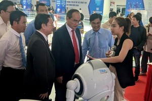 阮善仁同志（前中）參觀人工智能產品。（圖源：VOV）