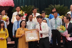 市人民議會主席阮氏麗（前左二）向出色集體與個人頒發獎狀。