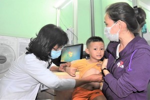 新平郡第二坊醫療站醫生在給一名小孩看診。（圖源：光輝）