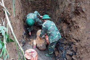 2名工兵將戰後遺留的老炸彈搬移現場。（圖源：英好）