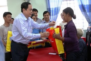 越南祖國陣線中央委員會主席陳清敏向廣義省災民表示親切慰問並贈送禮物。（圖源：明軍） 