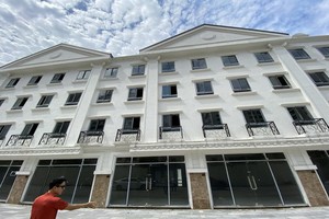 阮英俊站在面積少了26平方米的住房前面。