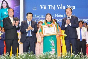 市委副書記阮胡海(左一)、《西貢解放報》執行副總編輯阮玉英(左二)與市教育與培訓廳長黎鴻山(右)給模範教師頒獎。（圖源：黃雄）