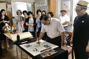 韓國書法愛好者觀賞林漢城即席揮毫。