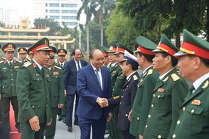 政府總理阮春福與越南人民軍總政治部領導幹部親切握手、互致問候。（圖源：光孝）