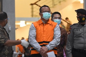 印尼海洋與漁業部長艾迪（中）在雅加達KPK大樓接受檢查後身穿監獄服，雙手戴上鐐銬。（圖源：I.E.S）