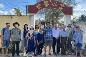 陸進義老師與鄉親和學生們在母校前合影。
