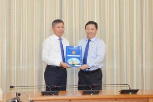 新任市教育與培訓廳副廳長楊智勇（左）從市人委會副主席楊英德手中接過人事委任《決定》。（圖源：孟和）