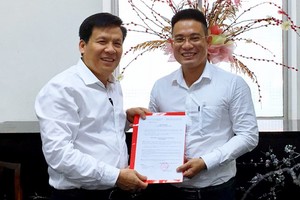 《西貢解放報》執行副總編輯阮玉英(左)向文忠孝同志頒授任命書。