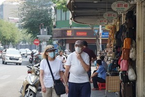 兩名外籍遊客佩戴口罩遊逛市中心街道。（圖源：清真）