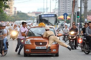 一名違規的計程車司機不但不遵守交警的號令，而且還直接朝交警的方向撞過來，交警措手不及，只好撲到車上的前蓋。