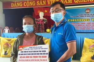 第五郡越南祖國陣線委員會副主席陳南德向貧戶贈送建溫情屋經費。