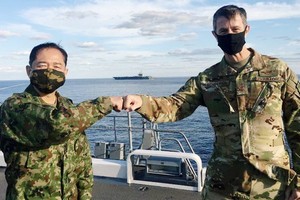 日本防衛省武官最高領導、統合幕僚長山崎幸二（左），與駐日美軍司令施奈德（右）擊拳合照。（圖源：路透社）