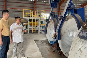 馬順通（左）與中國專家何明祥在研究新引進的無石棉矽酸鈣 板生產線。