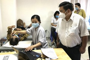 丁文森觀察醫生給病人在施手術前檢查眼睛。