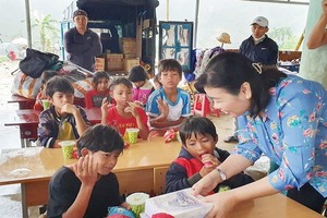 《西貢解放報》副總編輯李越中向廣義省茶林小學生贈送書本。