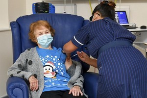 90歲老婦基南（左）接受護士為她注射輝瑞與BioNTech研製的新冠疫苗。（圖源：AP）