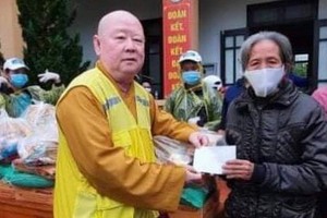 釋惟鎮法師向貧困者派發救濟品。