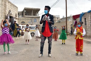 一名志願者指導也門貧民窟的女孩如何正確洗手。（圖源：聯合國兒基會）