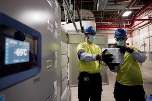 工作人員裝有輝瑞疫苗的箱子從航空運輸集裝箱中卸下。（圖源：Getty Images）