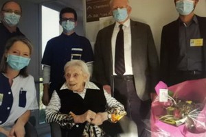 因為疫情的關係，大家在客廳裏都帶著口罩，給老壽星獻了一束鮮花，免了分享蛋糕的節目。（圖源：互聯網）