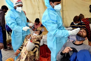 12月19日，乘客在印度德里一處巴士終點站接受新冠病毒檢測取樣。（圖源：新華社）