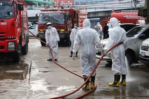 防疫人員在沙沒沙空府水產市場及附近展開消毒防疫工作。（圖源：Bangkok Post）