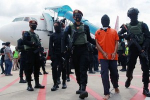 已被通緝14年的拉萬加（戴手銬者）被認定參與了2004年至2006年間發生在印尼南蘇拉威西省波索（Poso）中央市場和體育中心的多起爆炸案和其他一些恐怖行動。 （圖源：路透社）