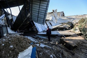 12月26日，一名男子在加沙城查看一間被損毀的工廠。（圖源：新華社）