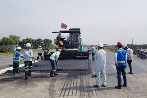 工人們在途徑前江省州城縣申九義鄉的路段進行舖築瀝青混凝土。（圖源：TTO）