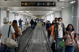 泰國曼谷素萬那普機場，旅客們都戴上口罩以防感染新冠病毒。（圖源：AFP）