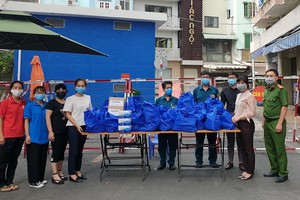 第五郡第九坊婦女會給隔離居民派發日用品。