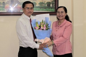 高清平同志（左）從市人民議會主席阮氏麗手中接過人事委任《決定》和祝賀鮮花。（圖源：元宇）