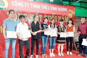 新富郡永揚刺繡有限責任公司黨支書兼工會主席廖玉山（右）向優秀工人 頒發獎狀。