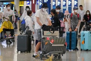 疫情期間“全副武裝”的乘客在機場準備登機。（圖源：互聯網）