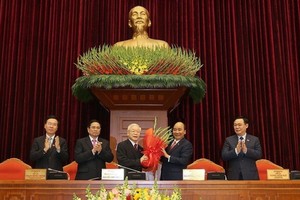 政府總理阮春福代表黨中央政治局向蟬聯黨中央總書記阮富仲同志送上鮮花。（圖源：越通社）