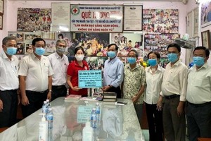 土龍木天后宮副理事長陳永安(右五)向故鄉人道中心代表謝氏梅贈送現金及物資。