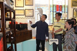 作者向懷舊物品捐贈者介紹陳列空間的西堤華人文物。