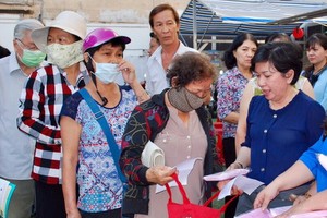 黎美淵向(右一)越華同胞贈送口罩和防疫手冊。