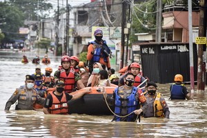 救援人員划船幫助民眾撤離。（圖源：AFP）