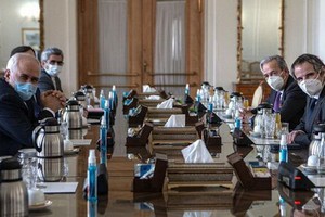 2月21日，在伊朗德黑蘭，伊朗外交部長扎里夫（左一）和國際原子能機構總幹事格羅西（右一）舉行會談。（圖源：新華社）