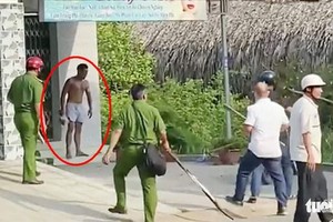 吳永貴（紅圈示）手持椰子刀襲擊咖啡店後站在外頭“迎戰”警方。（圖源：淮商）