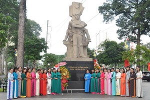 民族婦女工作組的成員穿長衫在第五郡民軍紀念台前合影。