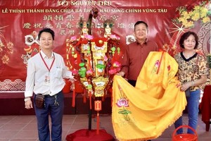 理事長鄒國榮(左)向陸國明夫婦轉交投得的《觀音蓮花寶燈》。