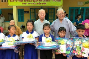 振淨法師（後排右一）向清貧小學生派發禮物。