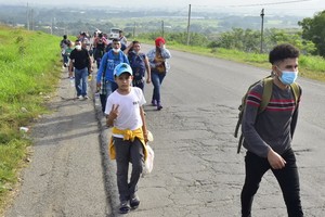 1月15日，在洪都拉斯北部城市科夫拉迪亞，中美洲民眾在當地公路上向北行進，希望能夠經由墨西哥進入美國。（圖源：新華社）