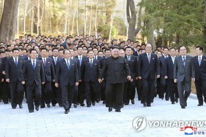 金正恩率各地黨委書記走過林間大道準備合影留念。（圖源：韓聯社/朝中社）